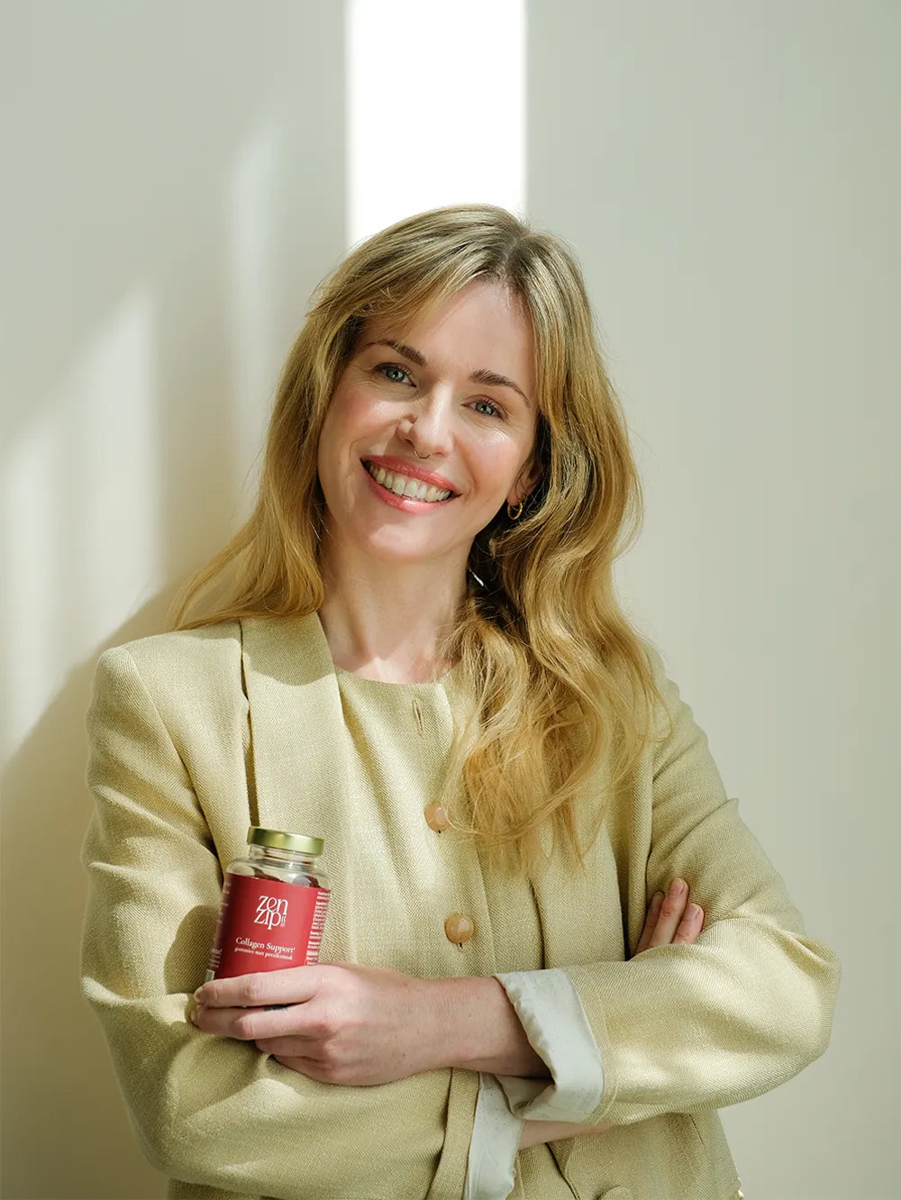 Zelfverzekerde vrouw met haar armen over elkaar en een ZenZip-it Collagen Support in beeld.