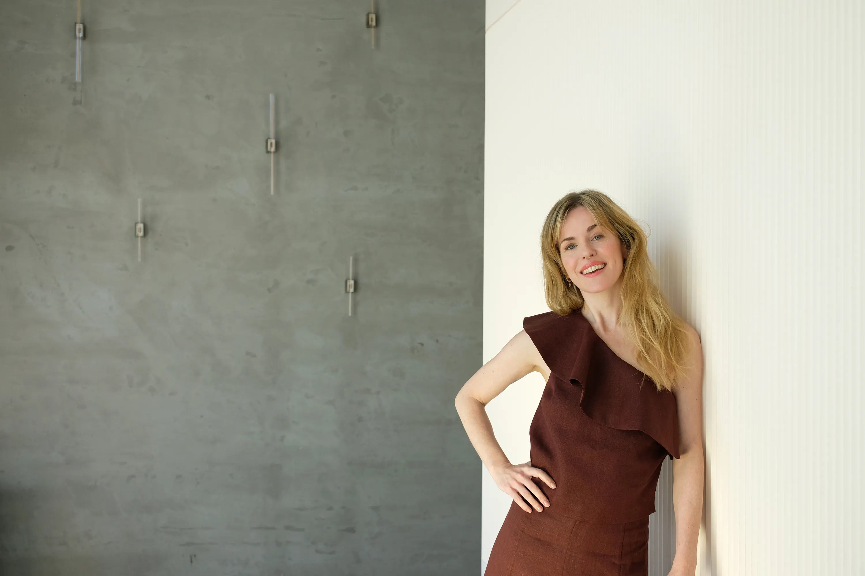 Josje Huisman leunend tegen een muur – mede-oprichter van ZenZip-it en het gezicht achter de visie op natuurlijke energie en balans